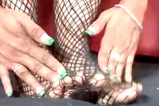 Black chick in fishnets gives a footjob